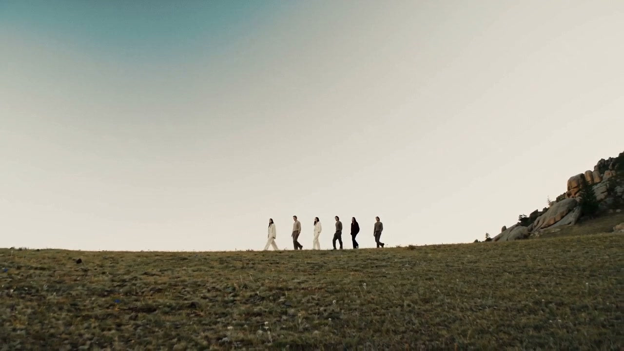 Models wearing knitwear in a grassy countryside landscape